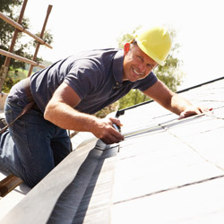 Roofer Working On Exterior Of New Home